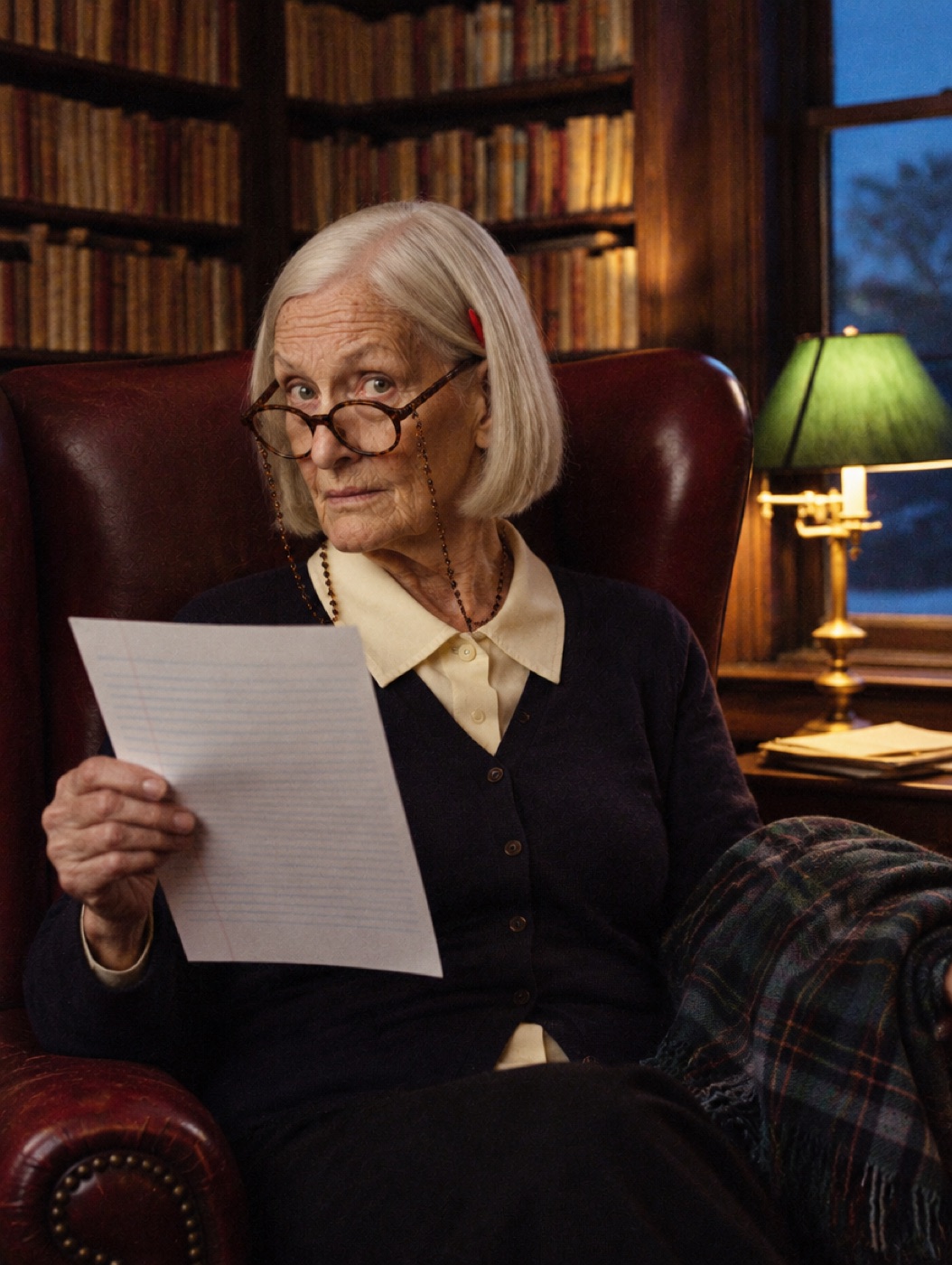 Mrs Pennington in her armchair holding an exam paper